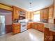 Traditional eat-in kitchen features natural wood cabinets, tile floors, and ample counter space for cooking at 2623 Shaw Ave, Gastonia, NC 28054