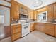 Charming kitchen with wood cabinets, white appliances, and plenty of natural light at 2623 Shaw Ave, Gastonia, NC 28054