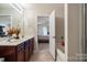 Bathroom with double sinks, vanity, tub, and a view into the bedroom with walk-in closet at 3428 Orr St, Charlotte, NC 28269