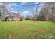 Large backyard with green grass, beautiful trees, and a view of the home's exterior at 5125 Belicourt Dr, Charlotte, NC 28277