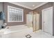 Elegant bathroom featuring a large tub, glass-enclosed shower, and tile flooring at 5125 Belicourt Dr, Charlotte, NC 28277