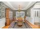Elegant dining room featuring a decorative chandelier, wallpaper, and hardwood floors at 5125 Belicourt Dr, Charlotte, NC 28277