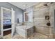 Beautiful bathroom featuring a tub, walk-in shower with glass door, and natural light at 615 Bourton House Dr, Charlotte, NC 28211