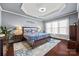 Serene main bedroom featuring a tray ceiling, a large bed, and bright windows at 615 Bourton House Dr, Charlotte, NC 28211