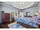Comfortable main bedroom boasts hardwood floors, tray ceiling, and ensuite bathroom at 615 Bourton House Dr, Charlotte, NC 28211