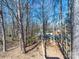 View of wooded backyard featuring mature trees behind house at 702 Selma Burke Ln, Matthews, NC 28105