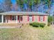 Quaint brick home featuring bright red shutters and a charming entryway at 702 Selma Burke Ln, Matthews, NC 28105