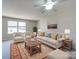 Bright living room features neutral furniture, area rug, and large windows at 702 Selma Burke Ln, Matthews, NC 28105