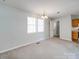 Open concept living room with neutral walls, carpet, natural light and chandelier at 702 Selma Burke Ln, Matthews, NC 28105
