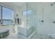 This bright bathroom features a glass enclosed shower and soaking tub next to a window at 7111 Anchorage Ln, Tega Cay, SC 29708