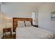 This bedroom features a textured wood headboard, and is naturally lit through a modern window fixture at 7111 Anchorage Ln, Tega Cay, SC 29708