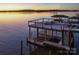A view of a modern boat dock on the lake at sunset, perfect for enjoying waterfront living at 7111 Anchorage Ln, Tega Cay, SC 29708