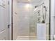 A glass-enclosed shower featuring decorative tile, a rainfall shower head, and convenient shelving at 7804 Renaissance Ct # A, Charlotte, NC 28226