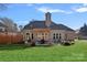 An expansive backyard with a stone patio, fire pit, outdoor kitchen, pergola, fountain, and lush green grass at 888 Craigmont Nw Ln, Concord, NC 28027