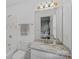 A well-lit bathroom with a granite countertop, white cabinets, brushed gold hardware, and a view into the bedroom at 888 Craigmont Nw Ln, Concord, NC 28027