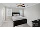 A well-lit bedroom features neutral walls, a ceiling fan, carpet, and a black bed frame with a decorative comforter at 888 Craigmont Nw Ln, Concord, NC 28027