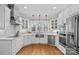 Bright, modern kitchen with white cabinets, stainless steel appliances, and hardwood floors at 888 Craigmont Nw Ln, Concord, NC 28027