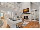 Bright living room with stone fireplace, hardwood floors, and an open staircase at 888 Craigmont Nw Ln, Concord, NC 28027