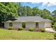 Lovely single-story home with stone accents, arched windows, and a well-manicured lawn surrounded by lush trees at 1205 Molokai Dr, Tega Cay, SC 29708