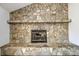 Close-up of a stone fireplace with a black metal insert, creating a rustic focal point at 1205 Molokai Dr, Tega Cay, SC 29708