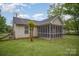 Rear view of the home featuring a screened-in porch, traditional siding, and access to the fenced backyard at 124 Woodside Ln, Lancaster, SC 29720