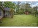 Large backyard featuring a fenced perimeter, a storage shed, a screened-in porch, and a well-kept lawn at 124 Woodside Ln, Lancaster, SC 29720