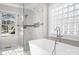 Modern bathroom featuring a glass enclosed shower with marble tile and a freestanding soaking tub at 126 Emerald Dr, Mooresville, NC 28117