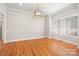 Bright dining room featuring hardwood floors, large window, and modern chandelier at 126 Emerald Dr, Mooresville, NC 28117