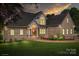 Beautiful brick home with a manicured lawn and elegant architectural details, illuminated at dusk at 126 Emerald Dr, Mooresville, NC 28117