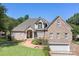 Charming brick home boasts a well-manicured lawn, a winding walkway, and a two-car garage at 126 Emerald Dr, Mooresville, NC 28117
