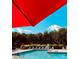 Community pool with a bright red umbrella and comfortable lounge chairs, perfect for relaxation at 126 Emerald Dr, Mooresville, NC 28117