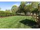 Large, fenced backyard featuring lush green grass and mature trees at 150 Harbor Cove Ln, Mooresville, NC 28117