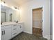 Bathroom with double vanity, modern fixtures, hexagon tile floors, and open access to the walk-in closet at 17025 Malone Ln, Mint Hill, NC 28227