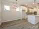 Bright kitchen with large island that opens to dining area with modern light fixture at 17025 Malone Ln, Mint Hill, NC 28227