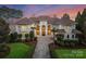 Elegant Mediterranean-style home featuring a tile roof, manicured landscaping, and a circular driveway at 18432 Harbor Light Blvd, Cornelius, NC 28031