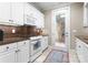 Efficient kitchen with white cabinets, modern appliances, and a door leading to the outside at 18432 Harbor Light Blvd, Cornelius, NC 28031