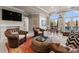 Comfortable living room with leather seating, fireplace, and large arched windows overlooking the lake at 18432 Harbor Light Blvd, Cornelius, NC 28031