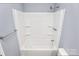 A white tub/shower insert with recessed shelves and a chrome showerhead make bathing relaxing at 333 S Eastway Dr, Troutman, NC 28166