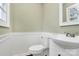 This updated bathroom features tiled wainscoting, white fixtures and modern finishes at 333 S Eastway Dr, Troutman, NC 28166