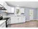 Bright kitchen with white cabinets, stainless steel appliances, luxury vinyl floors, and neutral walls at 333 S Eastway Dr, Troutman, NC 28166