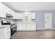 Bright kitchen with white cabinets, stainless steel appliances, luxury vinyl floors, and neutral walls at 333 S Eastway Dr, Troutman, NC 28166