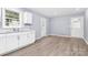 Bright kitchen featuring white cabinetry, a stainless steel sink and durable, light hardwood flooring at 333 S Eastway Dr, Troutman, NC 28166
