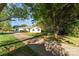 Quaint single-story house with a long driveway and mature trees shading the front yard on a sunny day at 341 Cline Dr, Salisbury, NC 28146
