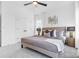 This bedroom features neutral walls, a ceiling fan, and a plush bed with decorative pillows at 3808 Odom Way, Charlotte, NC 28216