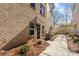 A view of the entrance of a brick townhome with an overhang and landscaping at 3808 Odom Way, Charlotte, NC 28216
