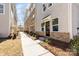 Exterior side view of a townhome showcasing a walkway, brick facade, and a stylish entrance at 3808 Odom Way, Charlotte, NC 28216