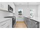 Modern kitchen with white cabinets, stainless steel appliances, gray island, herringbone backsplash and natural light at 3808 Odom Way, Charlotte, NC 28216