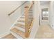Staircase with light wood steps and a dark metal railing at 4010 Citra Ln, Charlotte, NC 28217