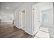 Bright hallway featuring hardwood floors and white doors, leading to various rooms at 4027 Vista Pine Dr, Charlotte, NC 28215