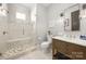 Modern bathroom featuring walk-in shower, wooden vanity, and neutral tile at 448 Iverson Way, Charlotte, NC 28203